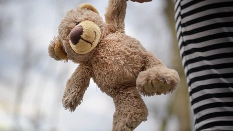 brown-teddy-bear-on-white-and-black-striped-textile.jpg